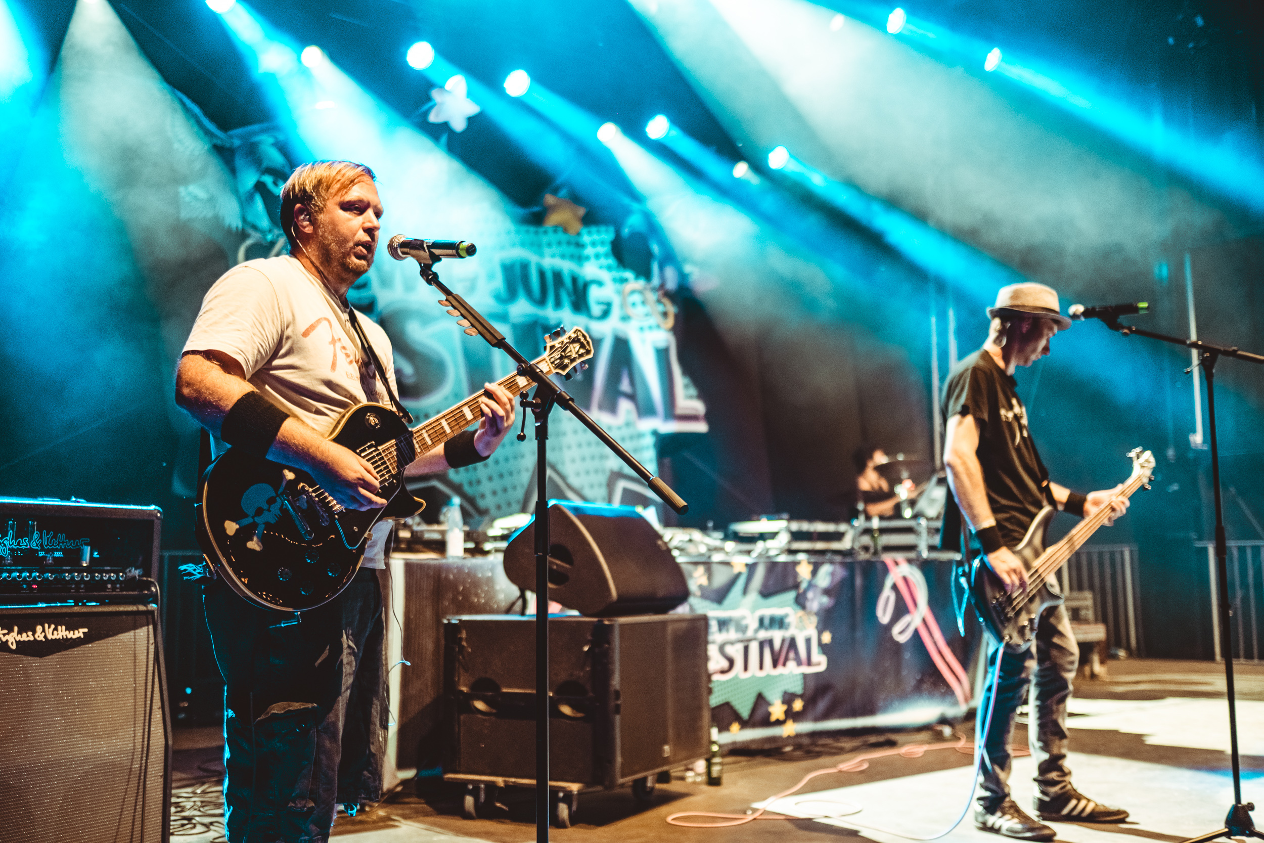 Auf der Bühne des ewig jung Festivals in Thüringen mit einem blauen Bühnenlicht von der linen Bühnenseite fotografiert, spielen Christoph Gitarre und Torsten den Bass